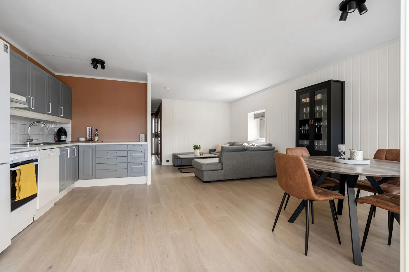Offene Küche mit grauen Fronten, Essplatz mit Lederstühlen und Wohnbereich mit Ecksofa (Kunrau, Altmarkkreis Salzwedel)