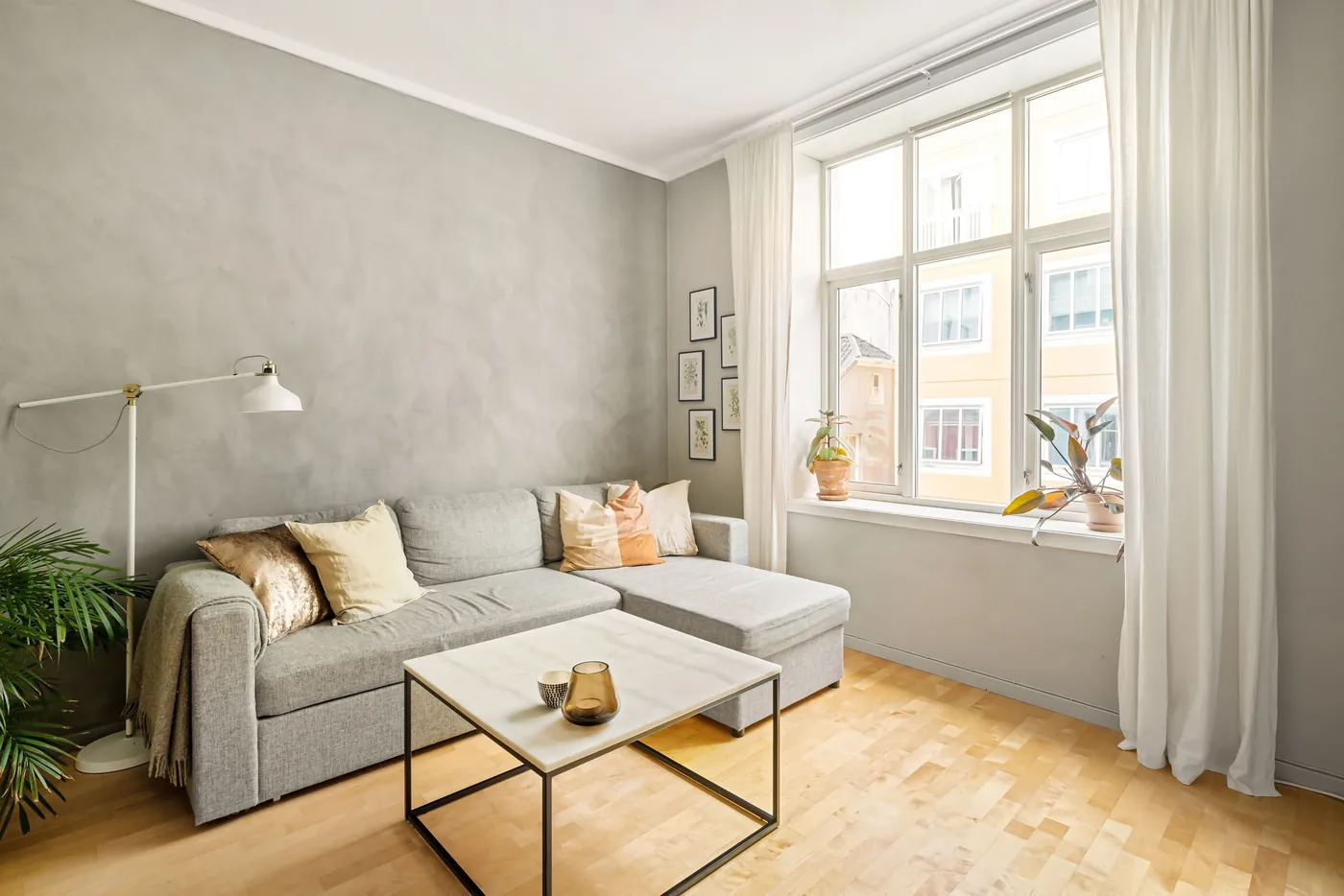 Helles Wohnzimmer mit grauem Ecksofa, Marmortisch und großem Sprossenfenster (Wassenach, Landkreis Ahrweiler)