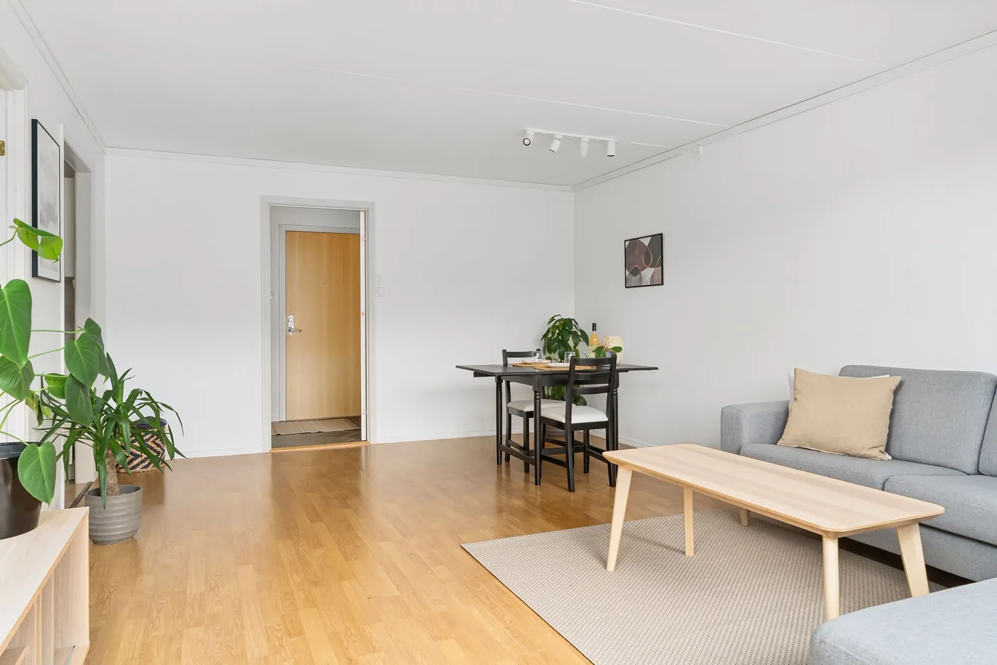 Heller Wohnraum mit Parkettboden, hellgrauem Sofa, Holztisch und kleinem Essplatz (Haselau, Kreis Pinneberg)