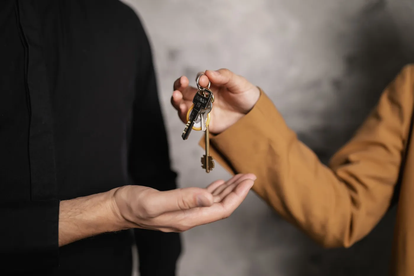 Übergabe eines Schlüsselbunds von einer Hand in die andere (Lienen, Kreis Steinfurt)